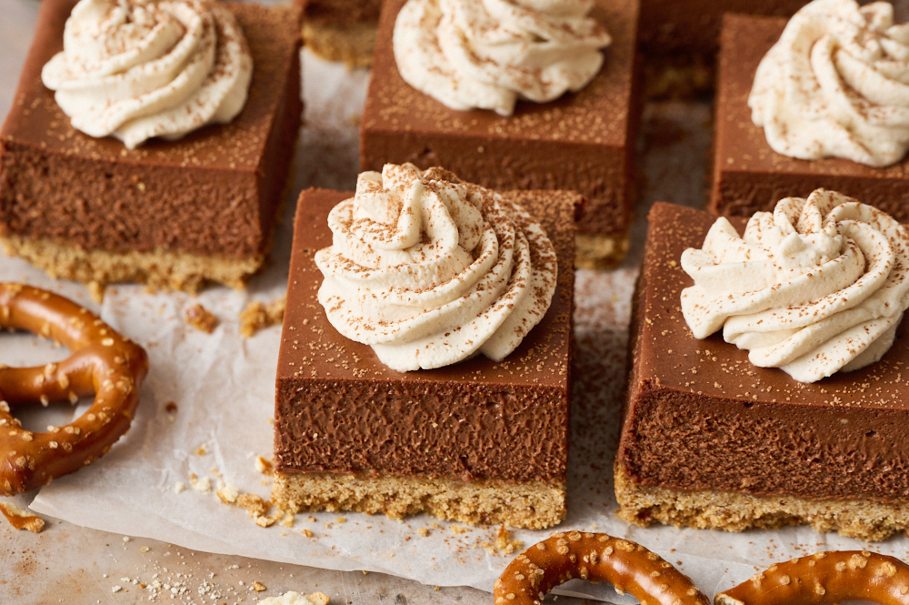 slices of Chocolate Stout Cheesecake Bars on parchment paper. 
