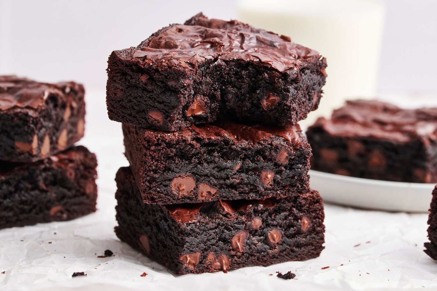 a stack of brownies with the top slice with a bite taken out. 