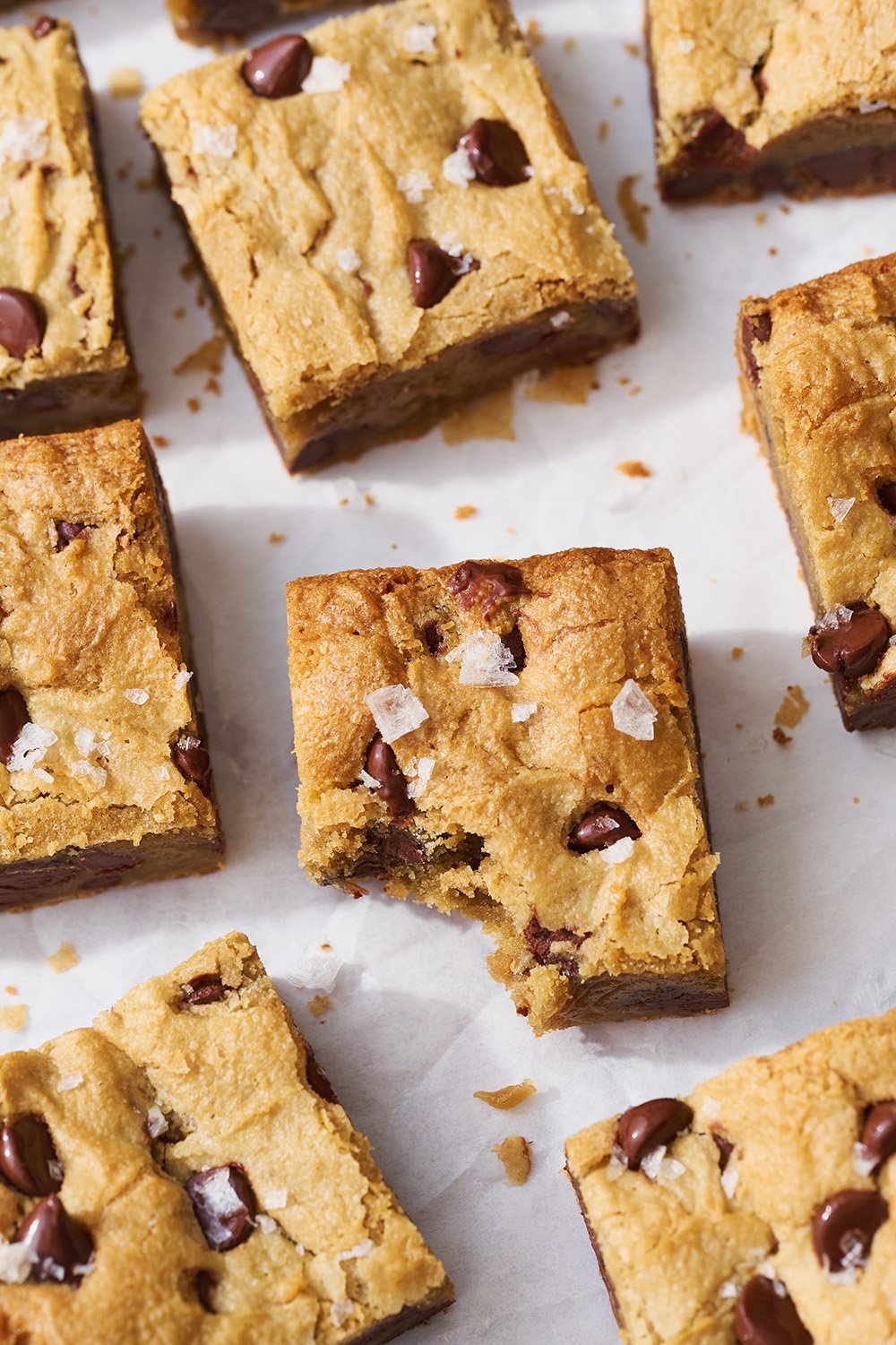 slices of blondies on a white background, with the center slice with a bite taken out.