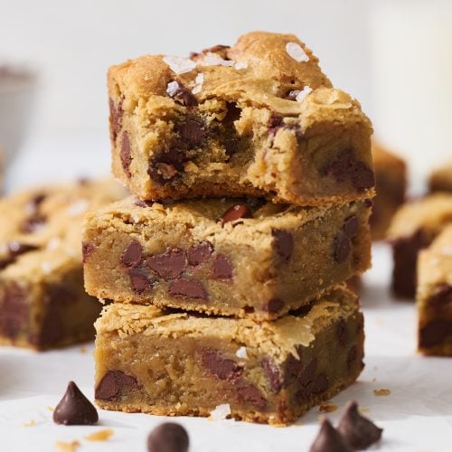 stack of easy gooey chocolate chip blondie recipe, top blondie with bite taken out