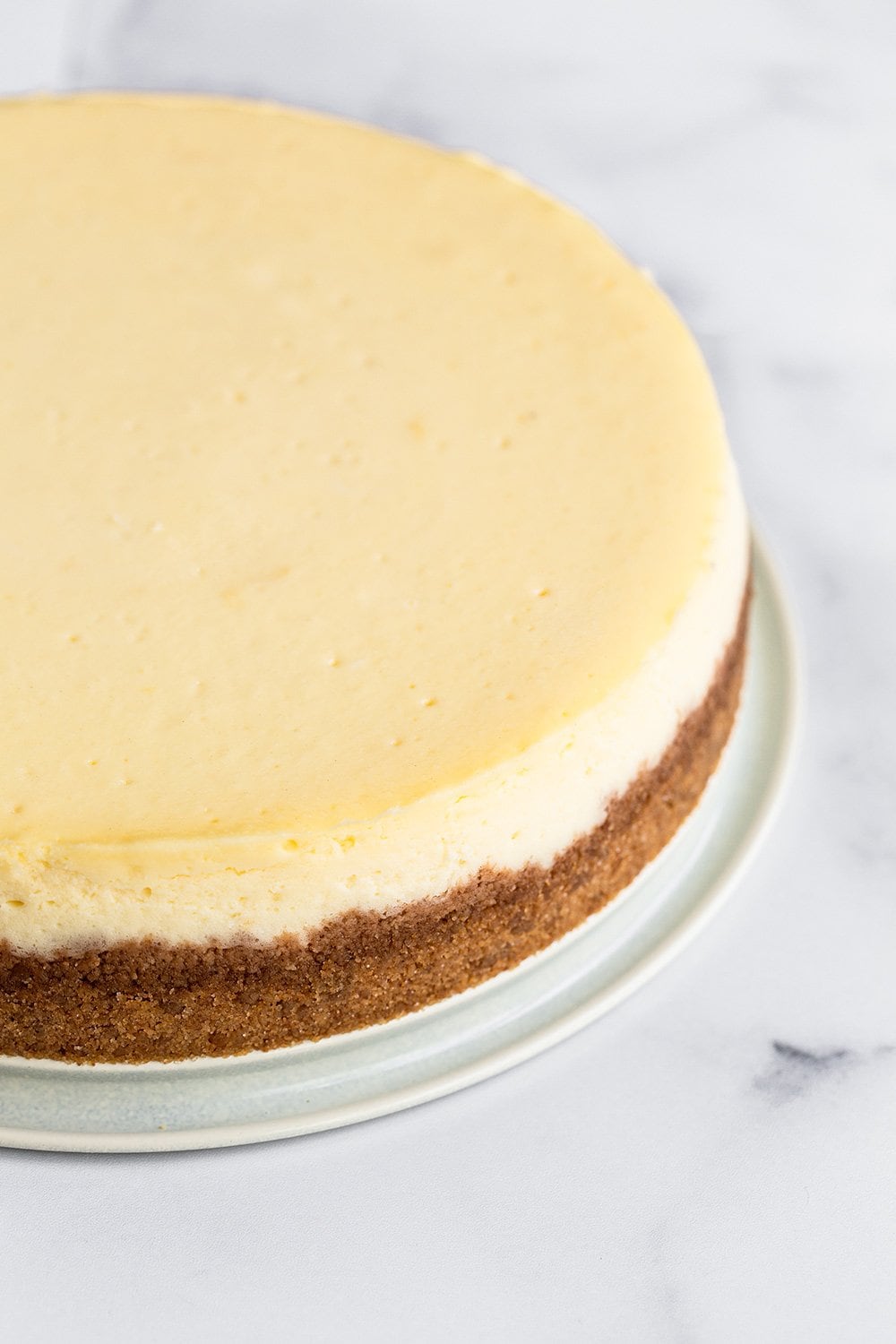 perfectly smooth and creamy cheesecake with no cracks and a graham cracker crust.
