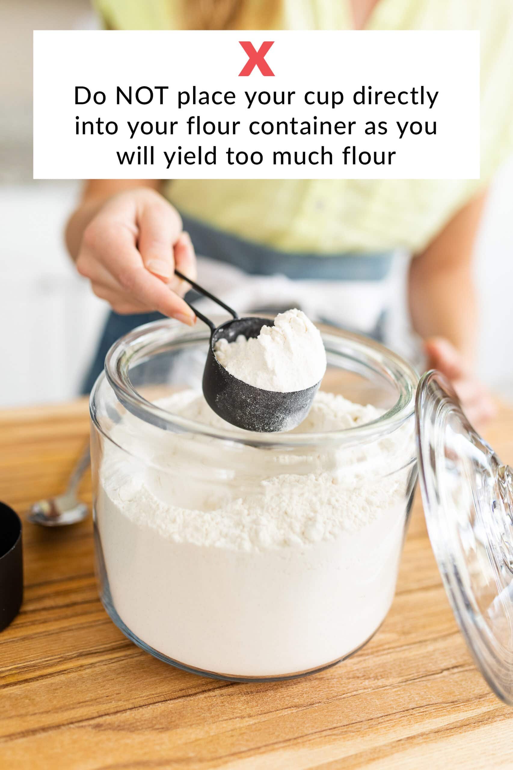 Tessa demonstrating 'what not to do' i.e. never scoop flour directly from the container, as this packs too much flour into the cup.