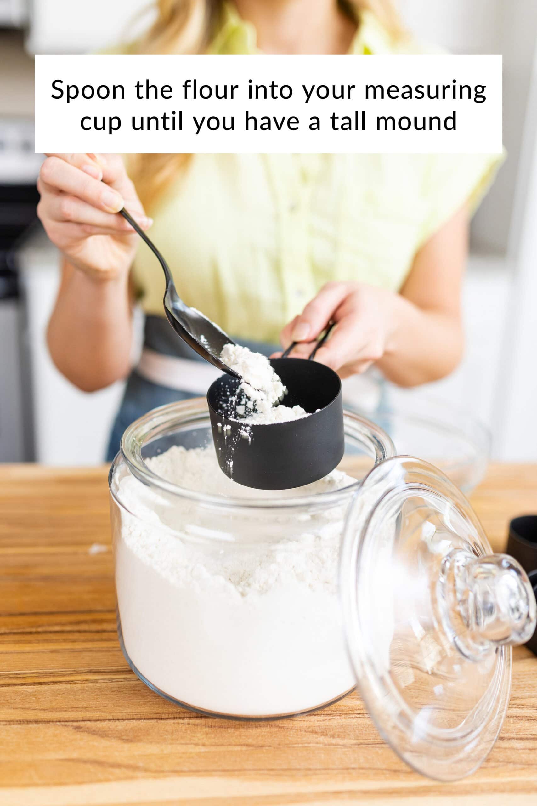Tessa spooning flour into the measuring cup, demonstrating the correct spoon-and-level method.