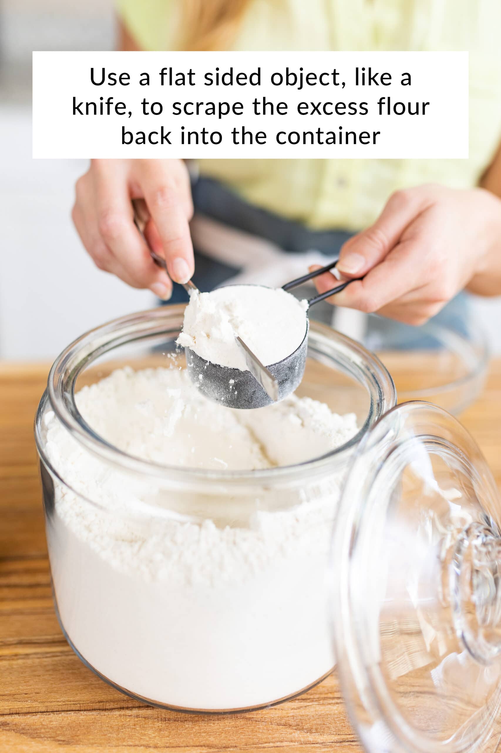 Tessa sweeping the excess flour back in the container.