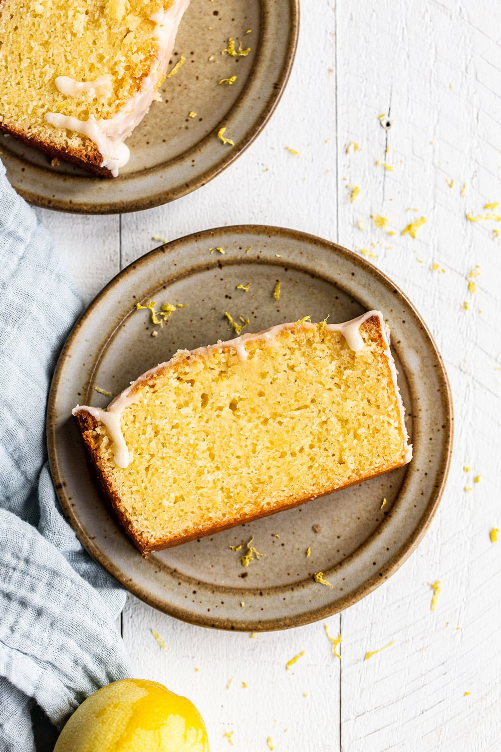 slice of iced lemon pound cake loaf on a plate, ready to serve.