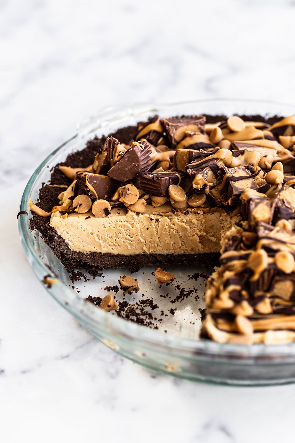 Simple homemade peanut butter pie in glass pie pan with slices already cut out.