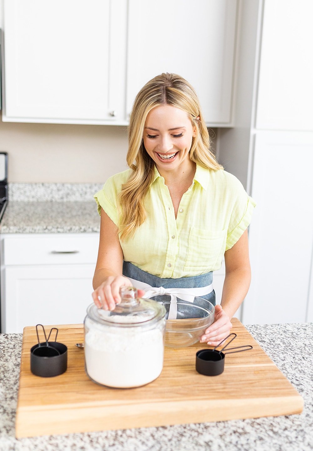 Chef Tessa measuring flour from a glass jar. 