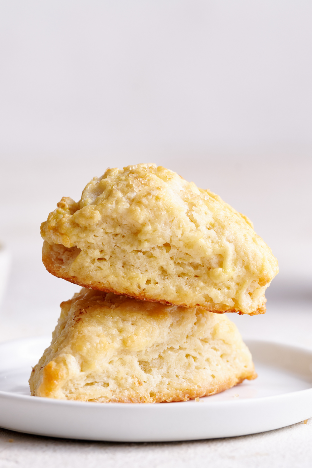 two scones stacked on a white plate.