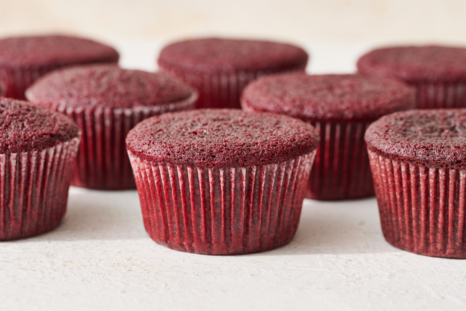 unfrosted red velvet cupcakes in a row.